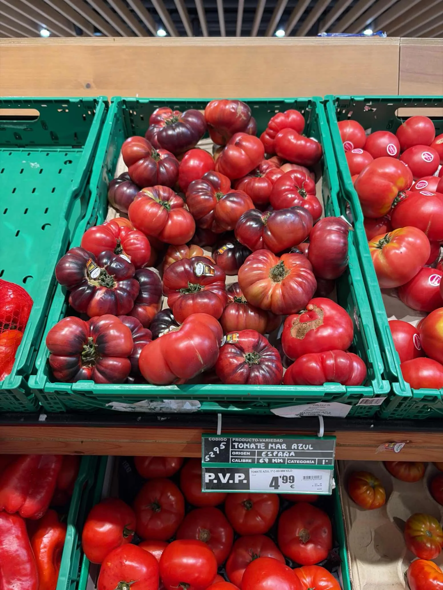 Dark heirloom tomatoes in a crate on a retail shelf